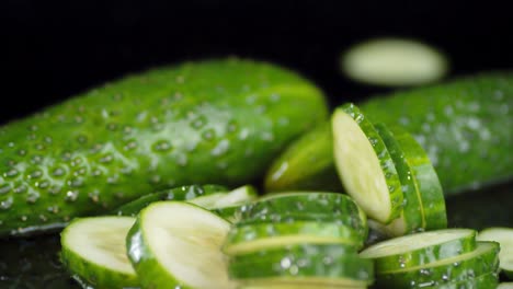rebanadas redondas de pepino fresco que caen en el agua con salpicaduras.