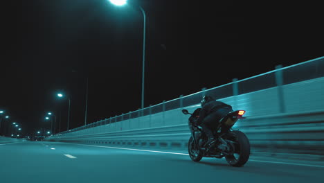 a man rides a sports motorcycle on a night track