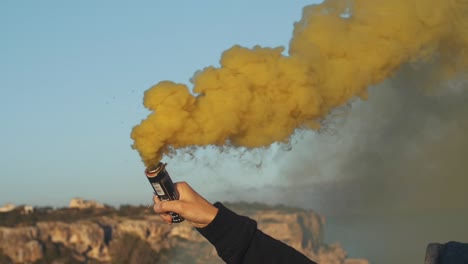 man holds a yellow smoke bomb in his hand - slow motion footage