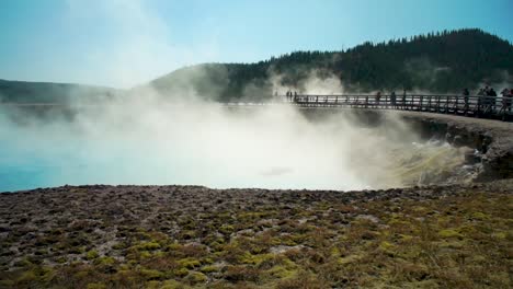 billowing clouds drift from hot steamy deep lakes at the magnificent prismatic hot springs in yellowstone national park