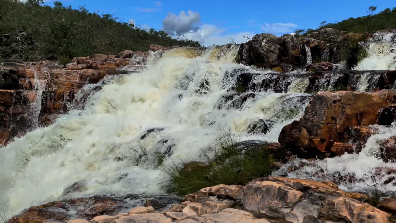 Ampie cascate a Cataratas dos Couros, regione della Chapada dos Veadeiros, Goiás, Brasile, paesaggio protetto del Cerrado con roccia di quarzite e forte flusso, panning lento e inquadratura rivelatrice.