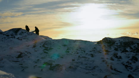 toma estática de una pareja de caminatas en la cima del lovstakken durante el amanecer