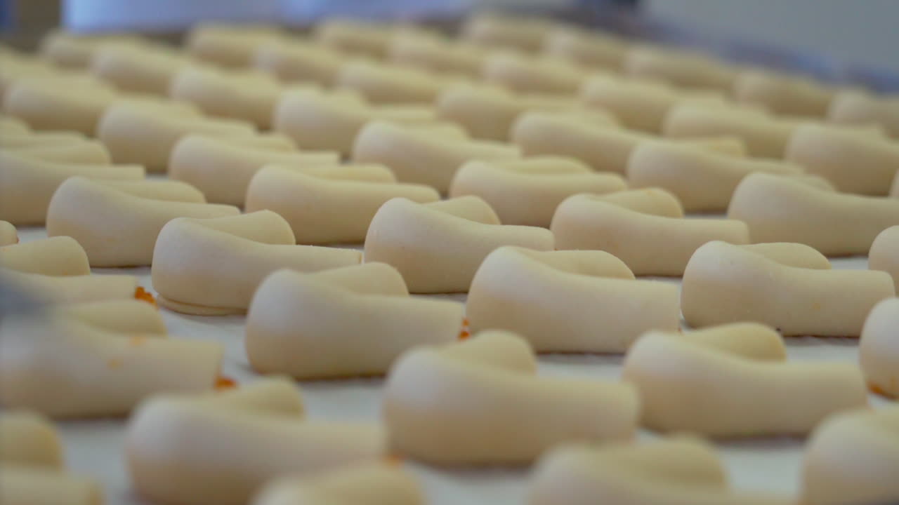 Sweet roll bagel cakes with jam on white cooking paper close up.