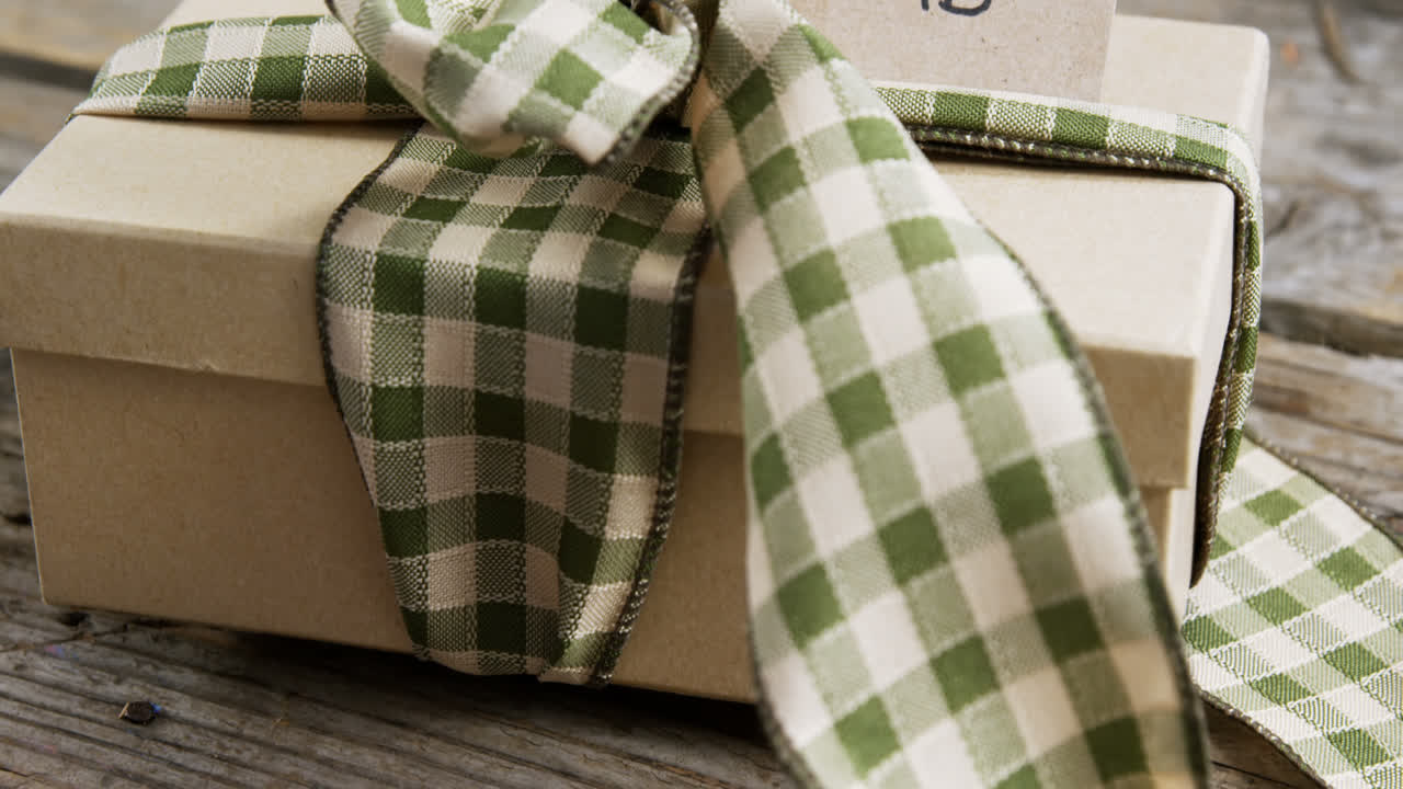 caja de regalos atada y tarjeta de feliz día de los padres en una tabla de madera