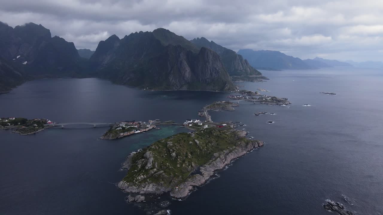 Archipelago island steps on glassy water with fjords and mountains on moody day