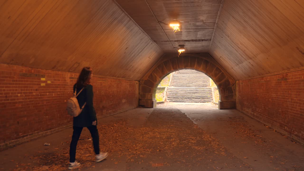 Walking alone in Central Park tunnel, NYC, calm autumnal atmosphere