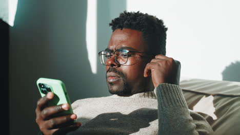 man using a smartphone on a couch