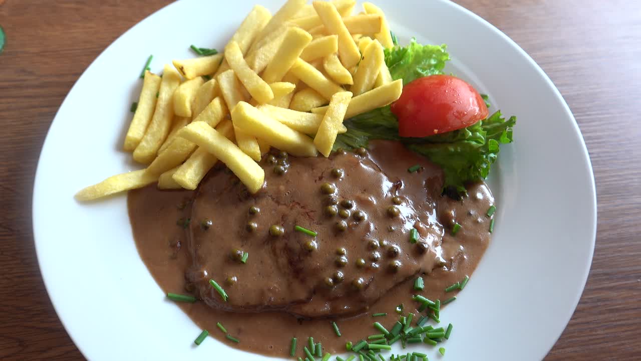 comiendo papas fritas con bistec a la pimienta
