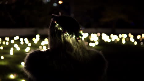 Mujer-Rubia-Con-Corona-De-Flores-Iluminada-Viendo-El-Festival-De-La-Luz-En-Vivid-Sydney,-Nsw,-Australia