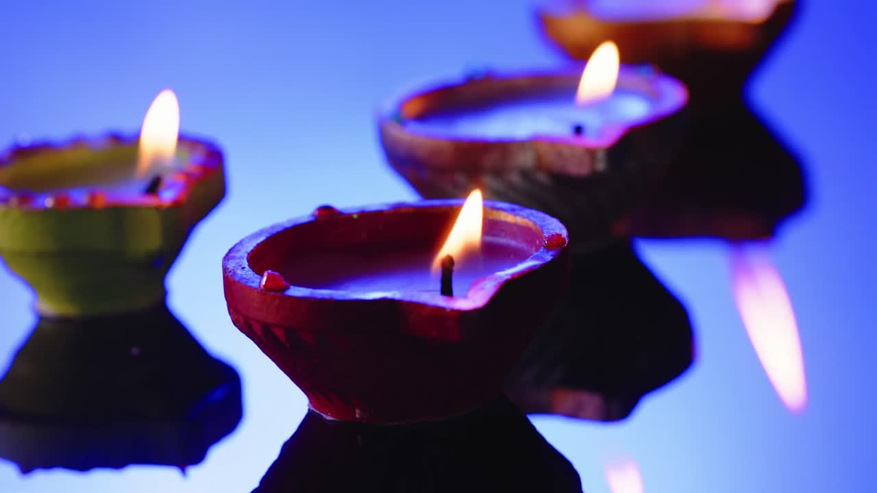 cerrar las velas encendidas en fila celebrando diwali sobre un fondo azul