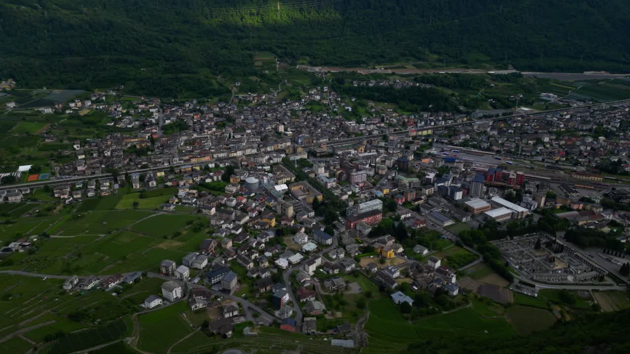 Bird’s-eye view of Tirano’s urban center with dense housing, rail infrastructure and surrounding farmland. Shot at Tirano, Italy (Tirano, Italia)