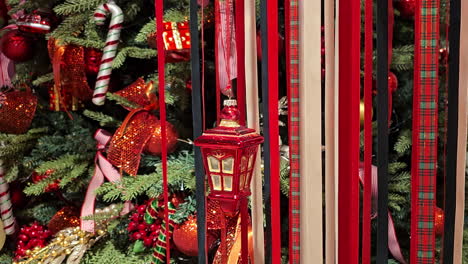 christmas decorations - colorful ribbons and toys hanging by decorated with balls and garlands christmas tree - close-up