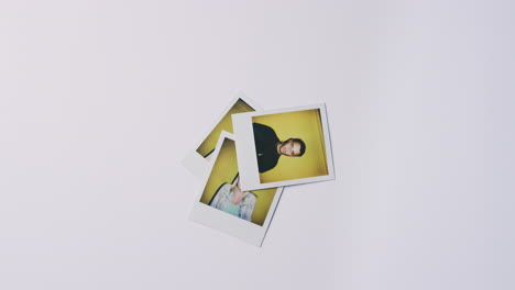 instant film photos of young men and women being thrown onto pile on white background