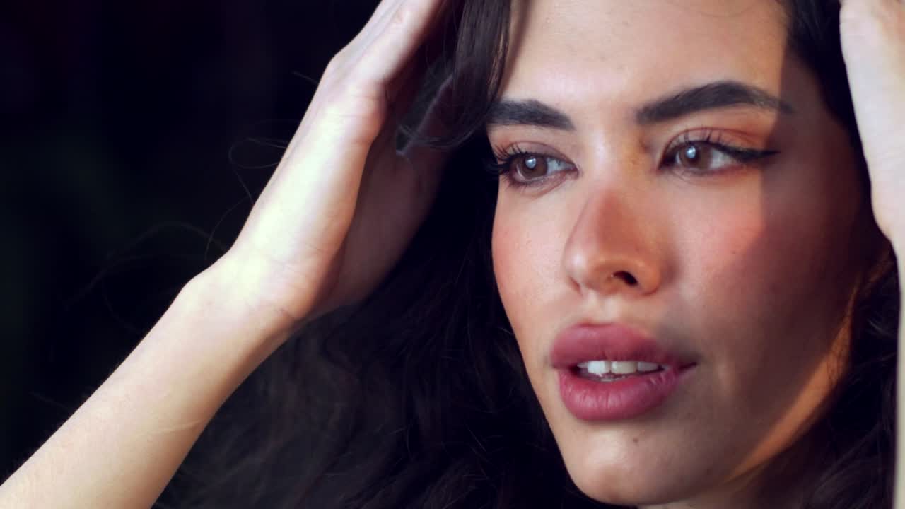 hermosa mujer en primer plano con cabello rizado negro y maquillaje, comercial de cuidado de la piel