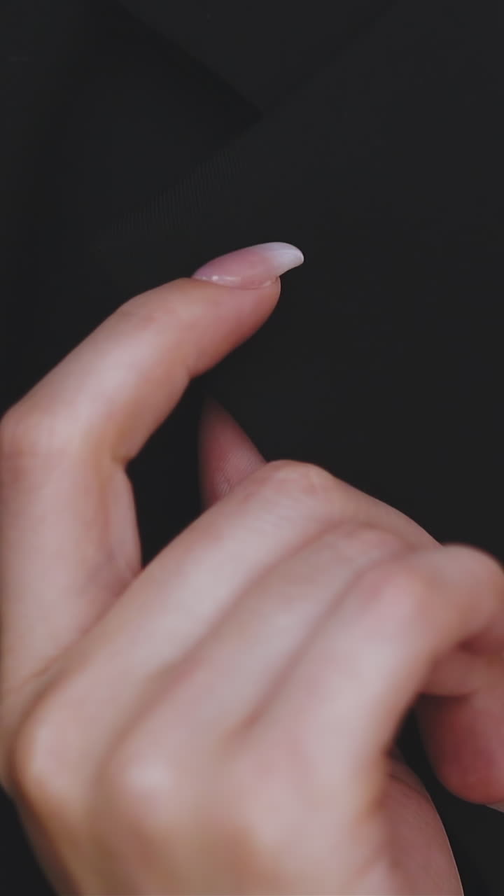 CU, slow motion: graceful young woman hand with elegant manicure near man wearing black suit jacket and white shirt without tie extreme close view