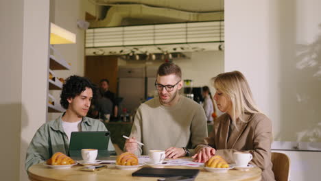 three colleagues have a business meeting at a coffee shop