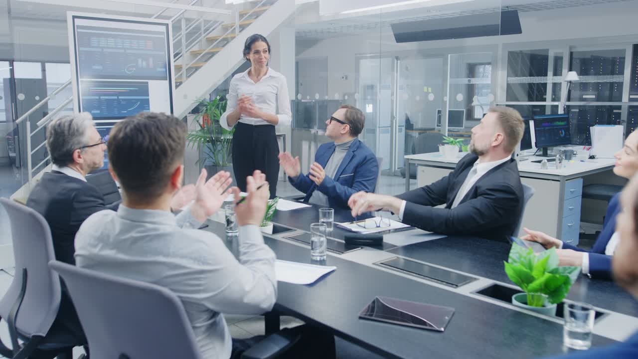 en la sala de reuniones corporativas: una ejecutiva utiliza una pizarra digital interactiva para una presentación a una junta directiva, abogados, inversores. todo el mundo aplaude. la pantalla muestra los datos de crecimiento de la compañía