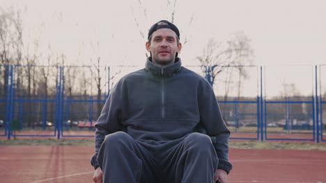 young disabled man in wheelchair looking at camera in basketball court 1