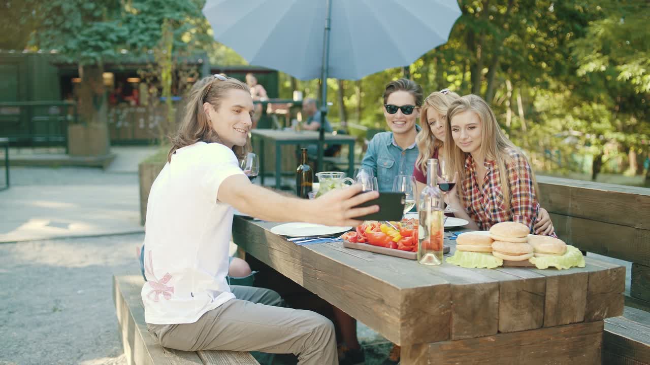 와인을 마시며 드폰으로 사진을 찍는 친구들.