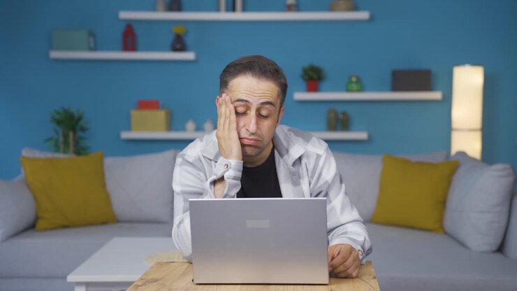 Mann am Laptop hat Kopfschmerzen