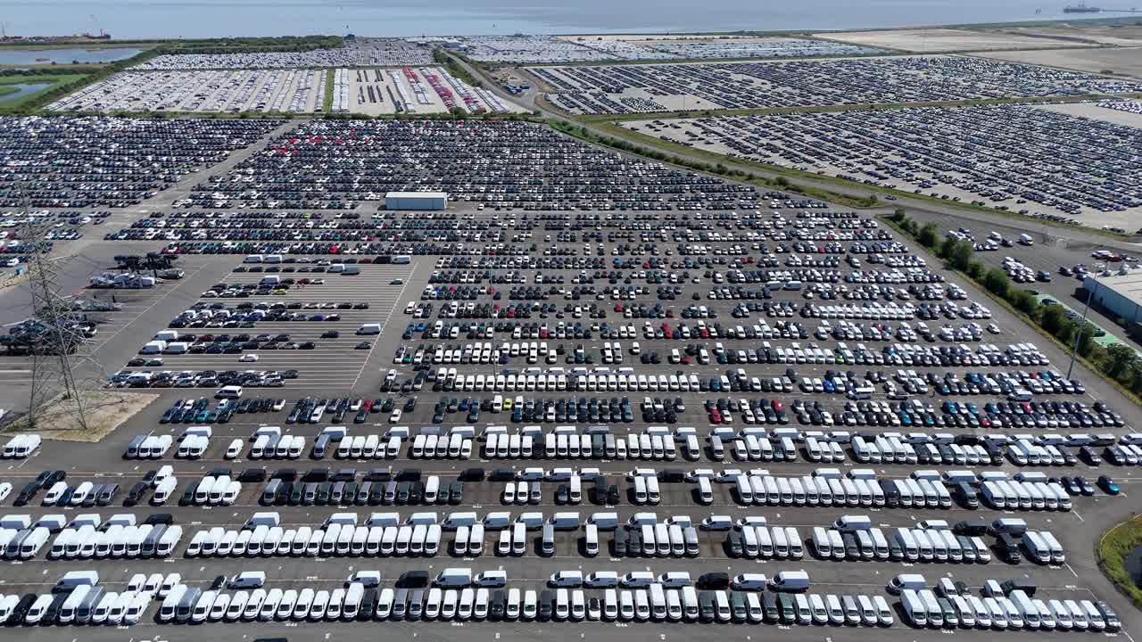 Wide aerial shot of new vehicles prepared for import and export at Humber Estuary industrial port England