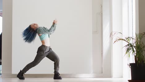 Portrait-of-caucasian-female-dancer-dancing-alone-in-dance-studio,-slow-motion