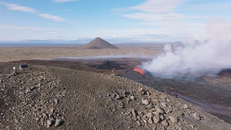 aerial view of litli hrutur volcano erupting with plume of smoke, iceland