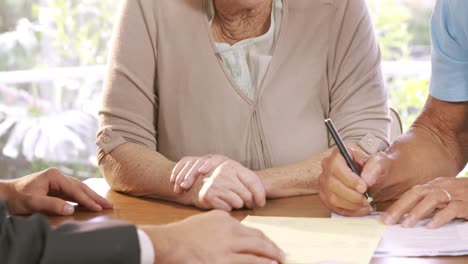 pareja de ancianos firmando un contrato