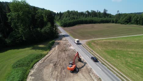 aerial view of excavator levelling ground in preparation for new road in switzerland