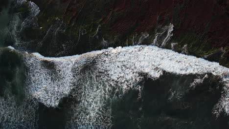 top down aerial view, pacific ocean waves breaking on shore at golden hour sun