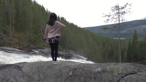 girl walks by a waterfall