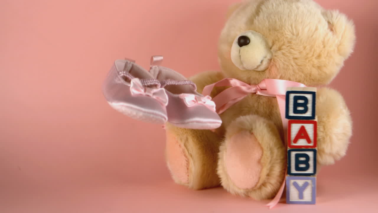 아기 신발이 테디 베어와 아기 블록 에 떨어집니다.