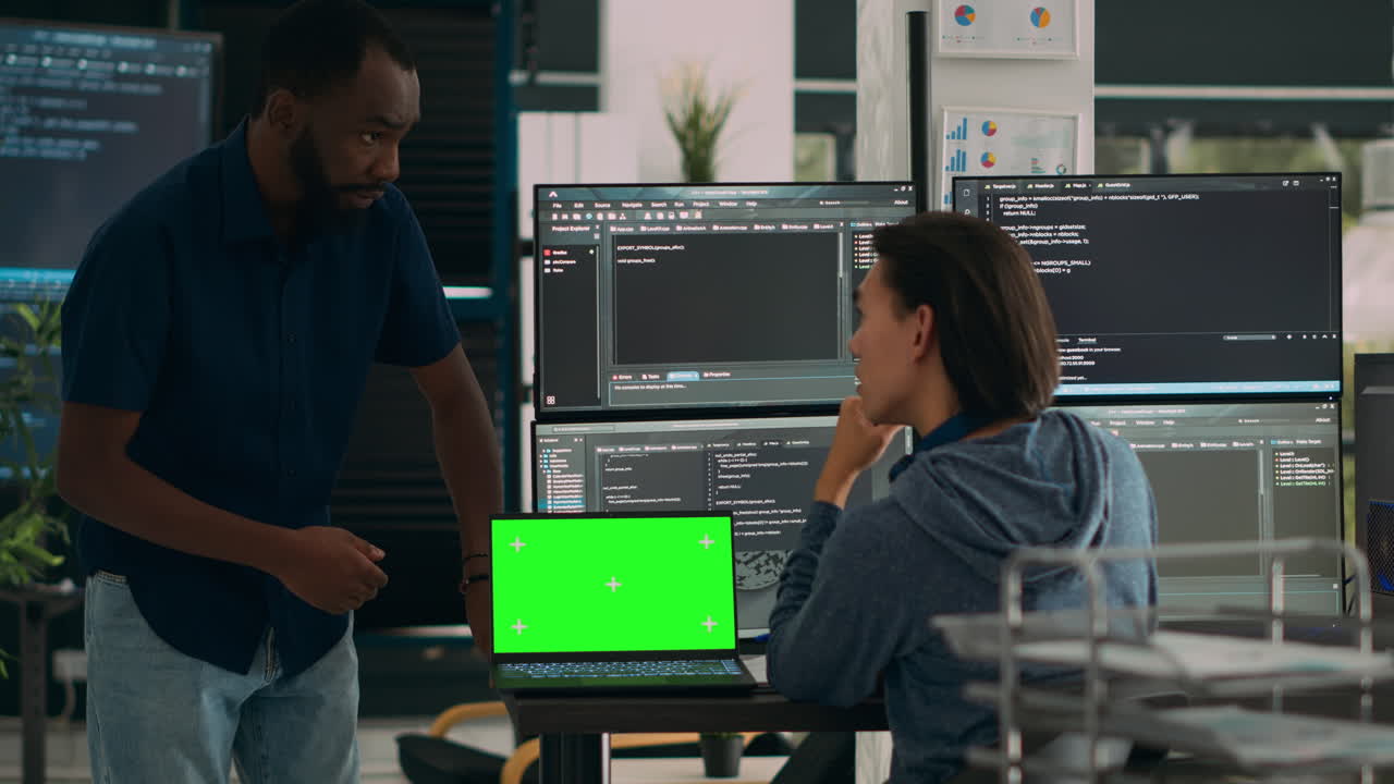 Diverse app developers working with greenscreen on laptop