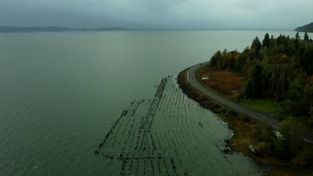 US, WA, Chinook, 2025-10-25 - Drone view of old dock pilings along the Columbia River just before a storm