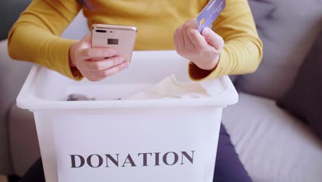 Detail-of-female-hands-making-a-donation-with-a-credit-card