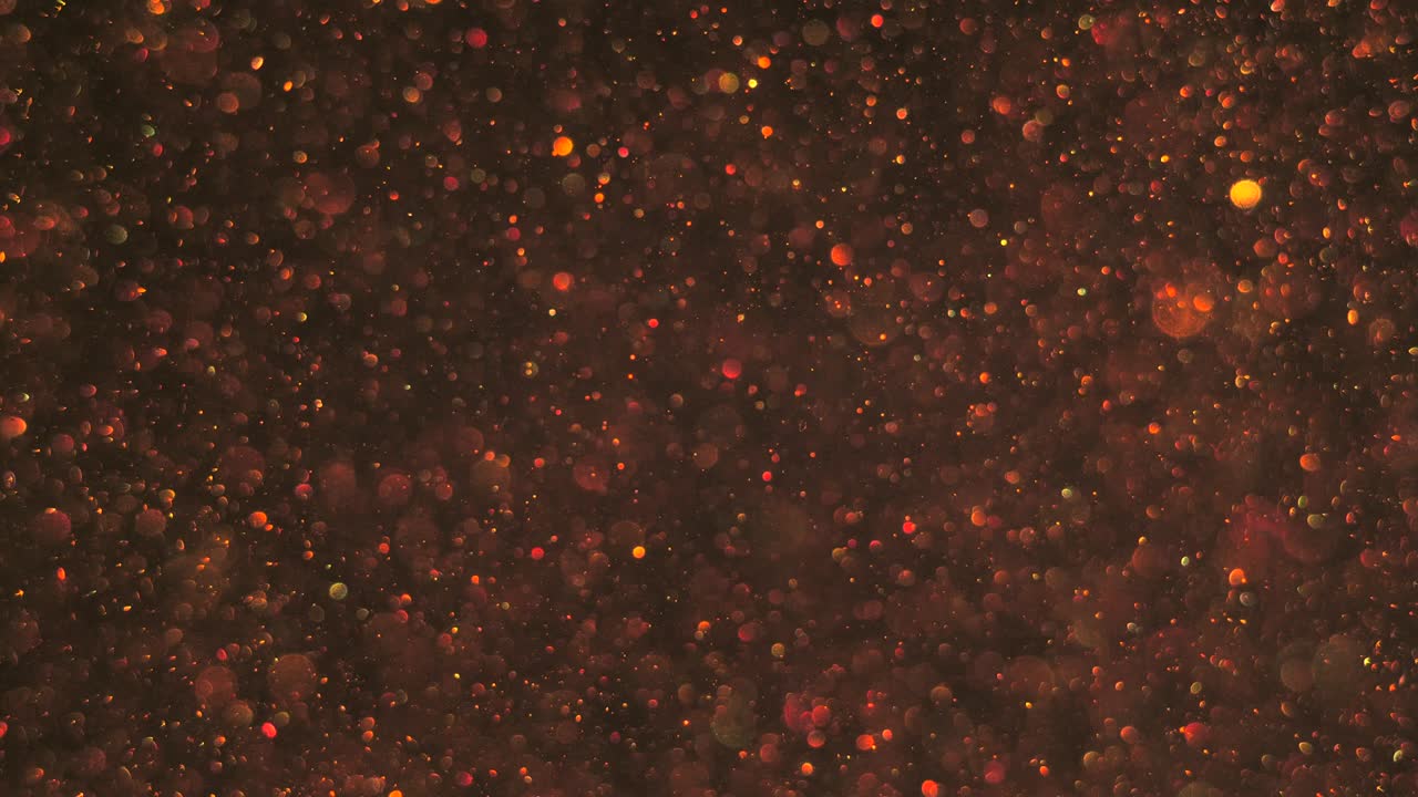 Light seamless transparent bokeh gold bubbles raising up smoothly in the air on dark cosmos background, shimmering.