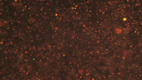 burbujas de oro bokeh transparente sin costuras que se levantan suavemente en el aire sobre un fondo cósmico oscuro, brillando.