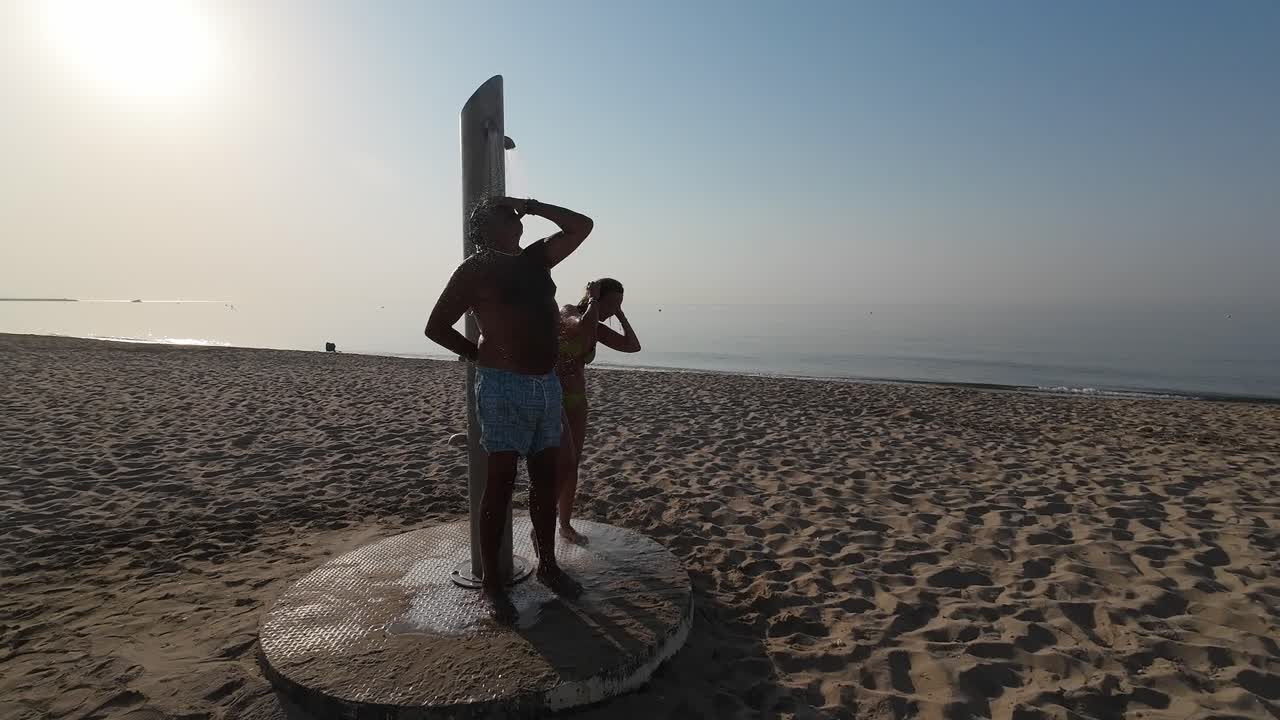People taking a shower at the beach