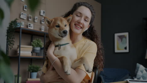 woman holding a shiba inu dog