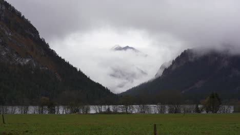 moody clouds obscure the mountains of the alps around lake heiterwang in tirol in austria on a rainy autumn day