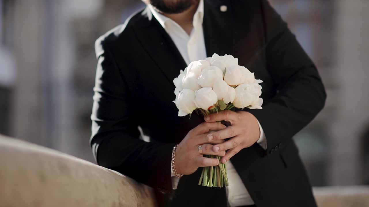 꽃 을 들고 있는 잘생긴 수염 이 있는 백인 남자