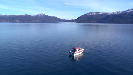 wide shot of a man on a motorboat fishing in norway