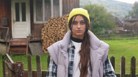 young woman in front of a rustic wooden cabin