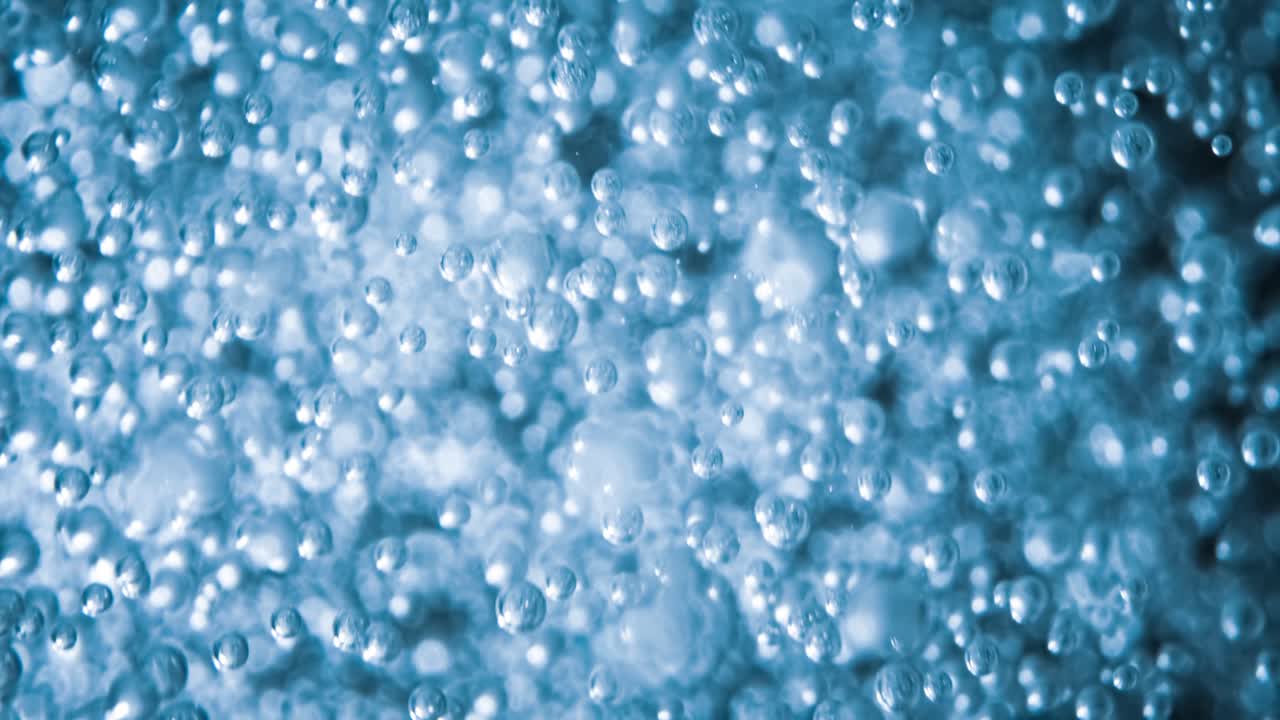 파란 물에 많은 물 거품이 가 ⁇ 게, 느린 움직임의 거품과 함께 추상적인 물 파동.