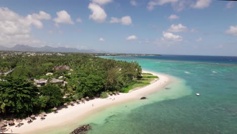 north beach in mauritius, turquoise waters lapping at white sands, dotted with sunbathers and palm trees, aerial view