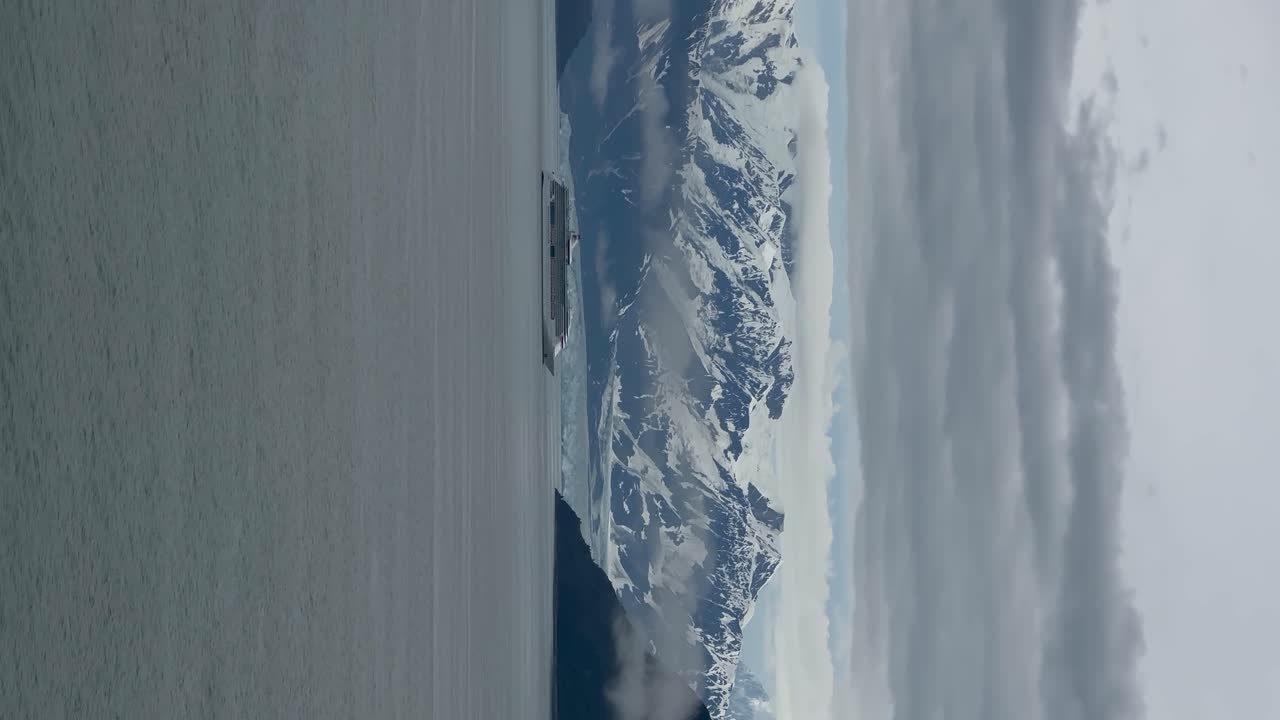 A cruise ship sailing close to Hubbard Glacier in Disenchantment Bay, Alaska - vertical orientation