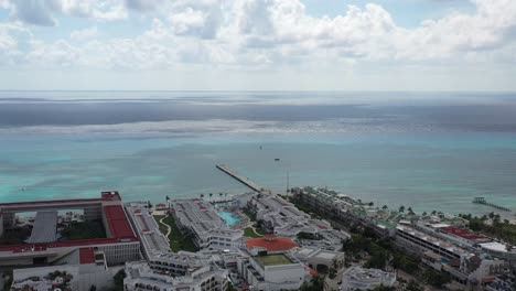 aerial shot heading the sea shows big hotel by the caribbean and a pier