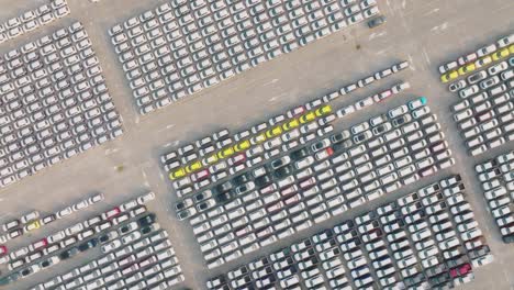 vista aérea de un gran estacionamiento centro de distribución de coches nuevos de un puerto marítimo moderno.