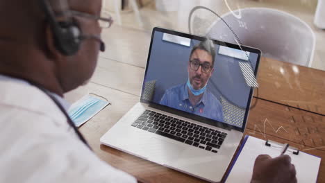 video conferencing with colleague, healthcare professional using laptop at office desk