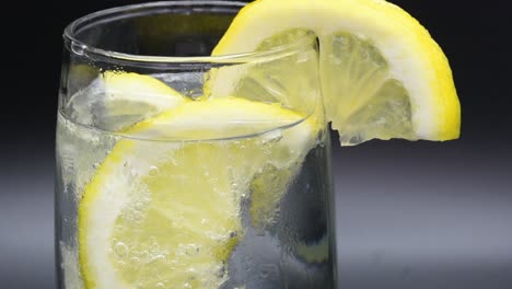 dejar caer rodajas de limón en un vaso con agua mineral